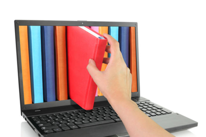 A Laptop Computer Displaying Books with Colorful Cover and with A Hand Pulling out a Book With A Red Cover